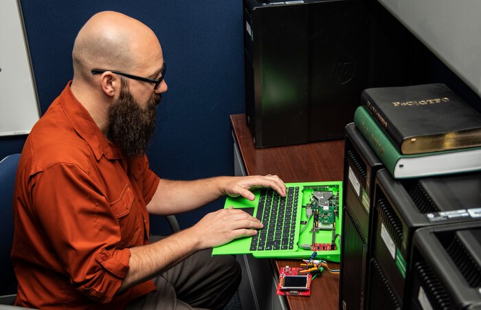 Socrates Frangis, director of Afloat Cybersecurity with the Office of Technology at NSWC PHD, performs a systems check on a prototype laptop.