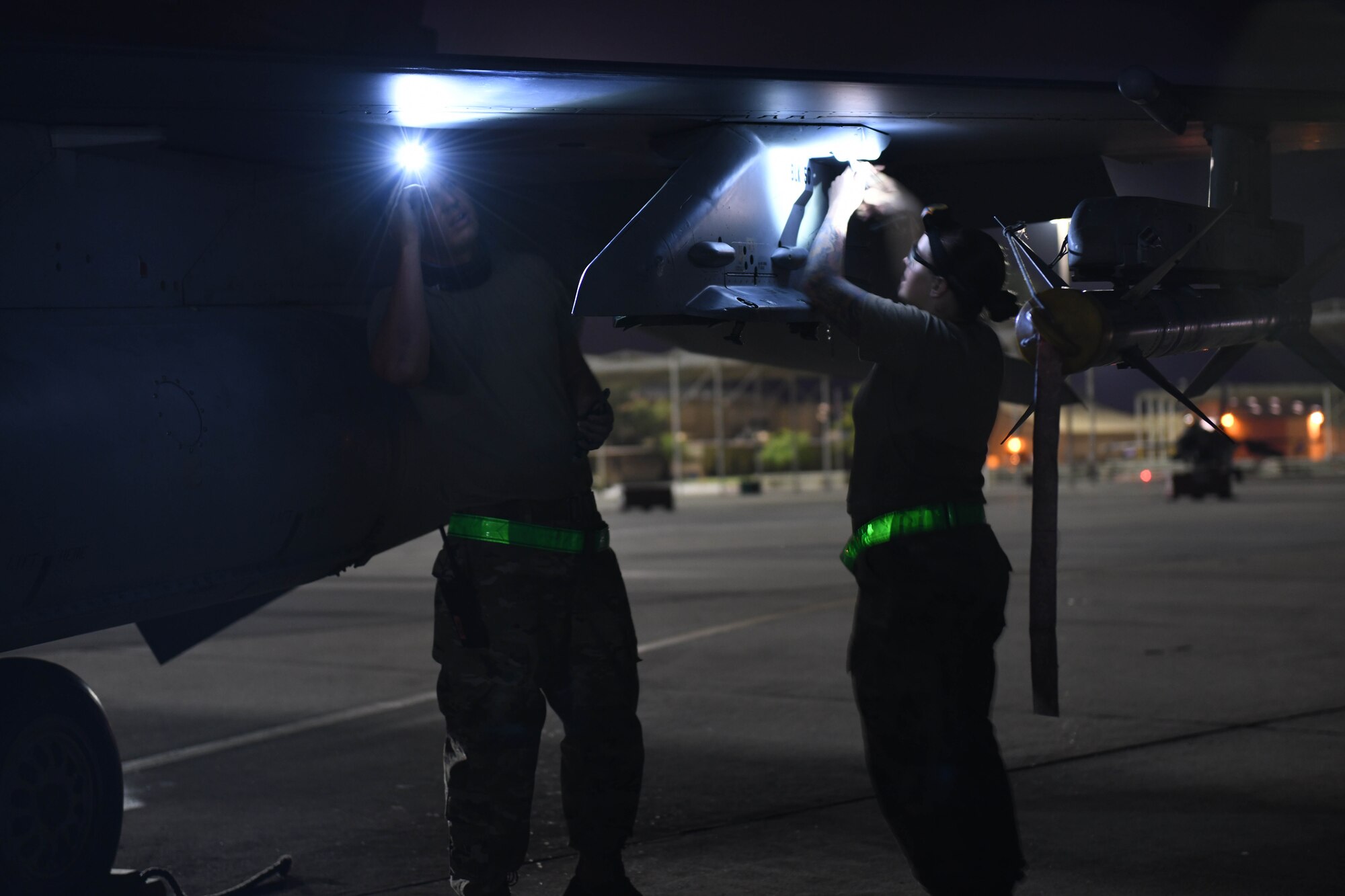 Senior Airman Kevin Bates (left) and Staff Sgt. Crysta Bass, 310th Aircraft Maintenance unit weapons load crew members, inspect an F-16 Fighting Falcon, June 24, 2020, at Luke Air Force Base, Ariz.