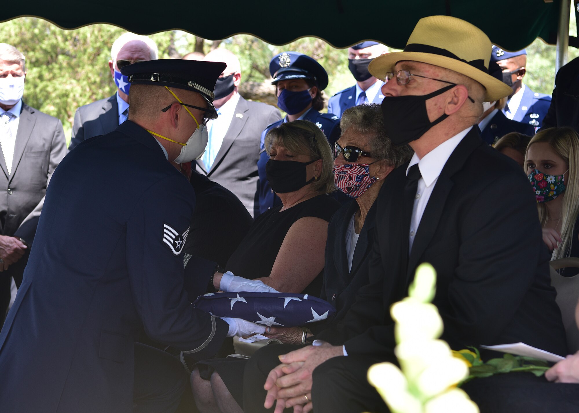 U.S. Air Force Staff Sgt. Quinten Pelletier, 17th Training Wing honor guardsman, presents widow JoAnne Powell a flag during the late retired Col. Charles Powell’s funeral at the Fairmont Cemetery, San Angelo Texas, July 8, 2020. The flag was a memento of Powell’s service within the Air Force. (U.S. Air Force photo by Staff Sgt.Chad Warren)