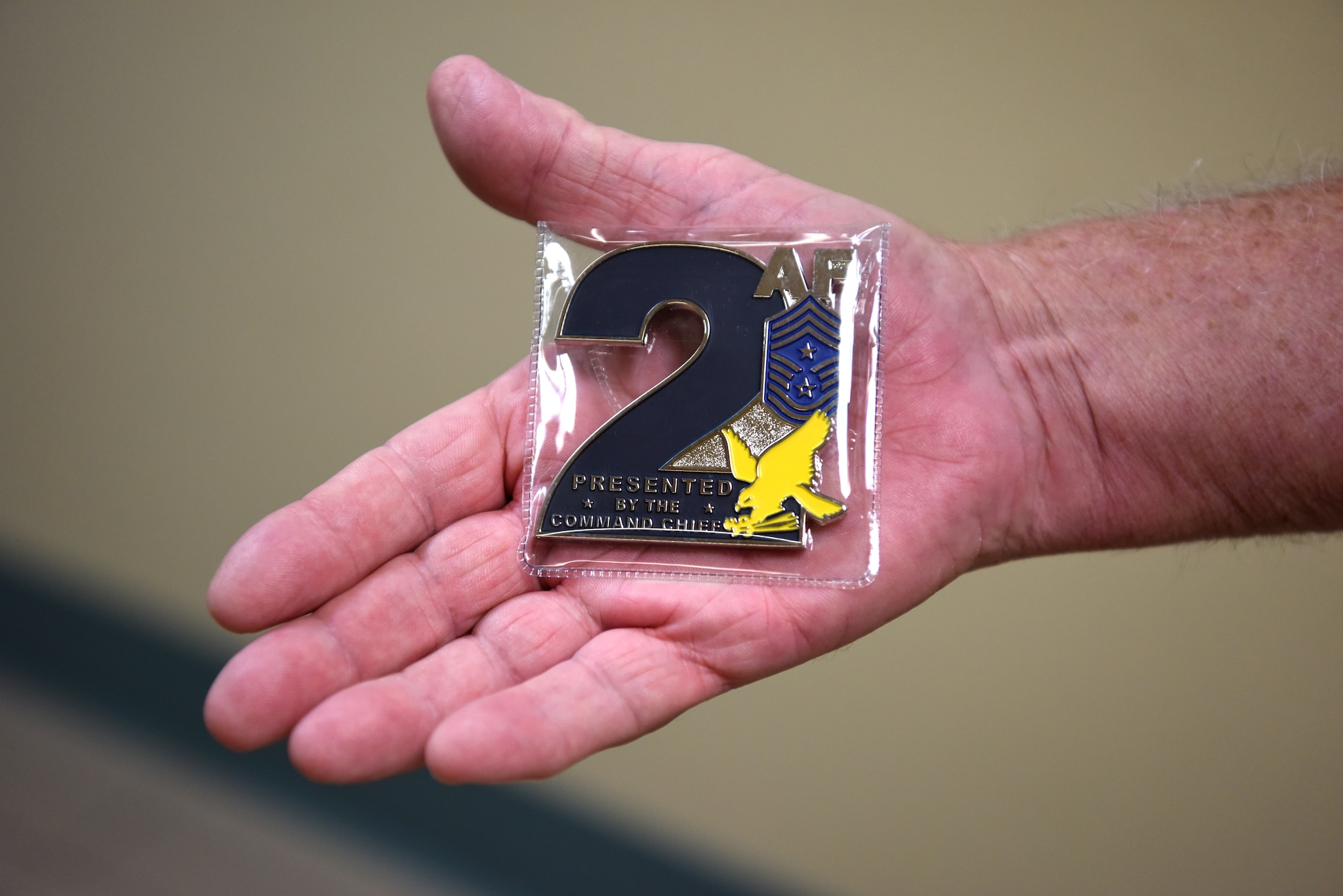 Jim Bailey, 334th Training Squadron air traffic control instructor, displays a Second Air Force command chief coin inside Cody Hall at Keesler Air Force Base, Mississippi, June 17, 2020. Bailey served in the Air Force as an air traffic controller from 1961-1966 and then at the age of 76 he earned his associate's degree so he could become an air traffic control instructor. Bailey was coined by U.S. Air Force Chief Master Sgt. JoAnne Bass, Second Air Force command chief. (U.S. Air Force photo by Senior Airman Suzie Plotnikov)