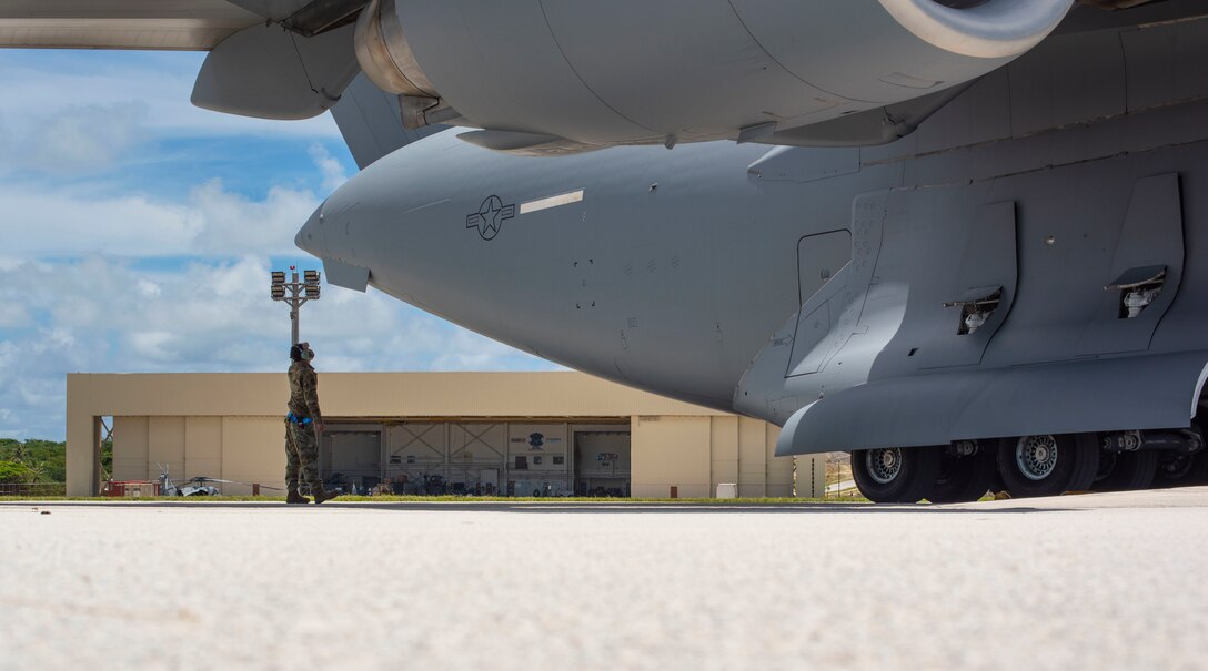Senior Airman Luis Godinez, 734th Air Mobility Squadron crew chief, inspects a C-17 Globemaster assigned to the 154th Wing, Hawaii Air National Guard, after a Joint Forcible Entry Operation (JFEO) jump into Andersen Air Force Base, Guam, June 30.