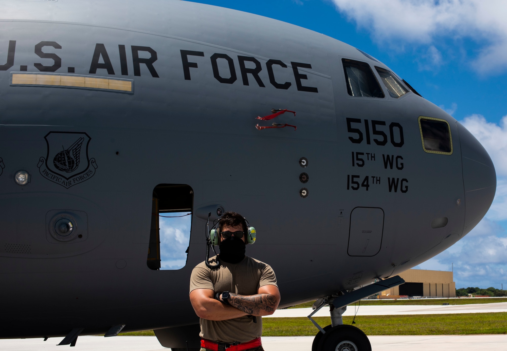 U.S. Air Force Staff Sgt. Tyler Garcia, 734 Air Mobility Squadron electrical and environmental systems craftsman, poses for a photo in front of a C-17 Globemaster assigned to the 154th Wing, Hawaii Air National Guard, after a Joint Forcible Entry Operation (JFEO) jump into Andersen Air Force Base, Guam, June 30.
