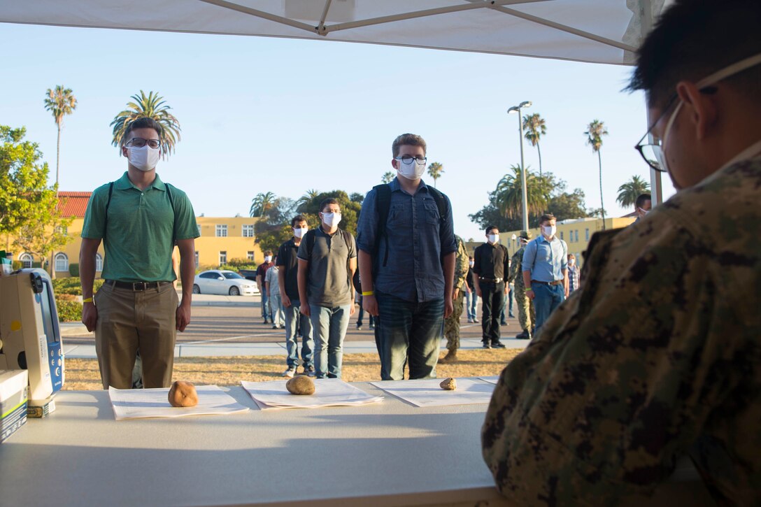 New recruits with Lima Company, 3rd Recruit Training Battalion, are medically screened after arriving at Marine Corps Recruit Depot, San Diego, July 6, 2020. As recruits arrive to the depot in the future, they will enter a staging period of 14 days during which they will be medically screened, monitored, and provided classes to prepare and orient them to begin recruit training. All of this will occur before they step onto our iconic yellow footprints and make that memorable move toward earning the title Marine. Current planning and execution remain fluid as the situation continues to evolve. The health and well-being of our recruits, recruiting and training personnel, and their families remain our primary concerns. All recruits will be screened and tested for COVID-19 prior to beginning recruit training. (U.S. Marine Corps photo by Cpl. Brooke C. Woods)