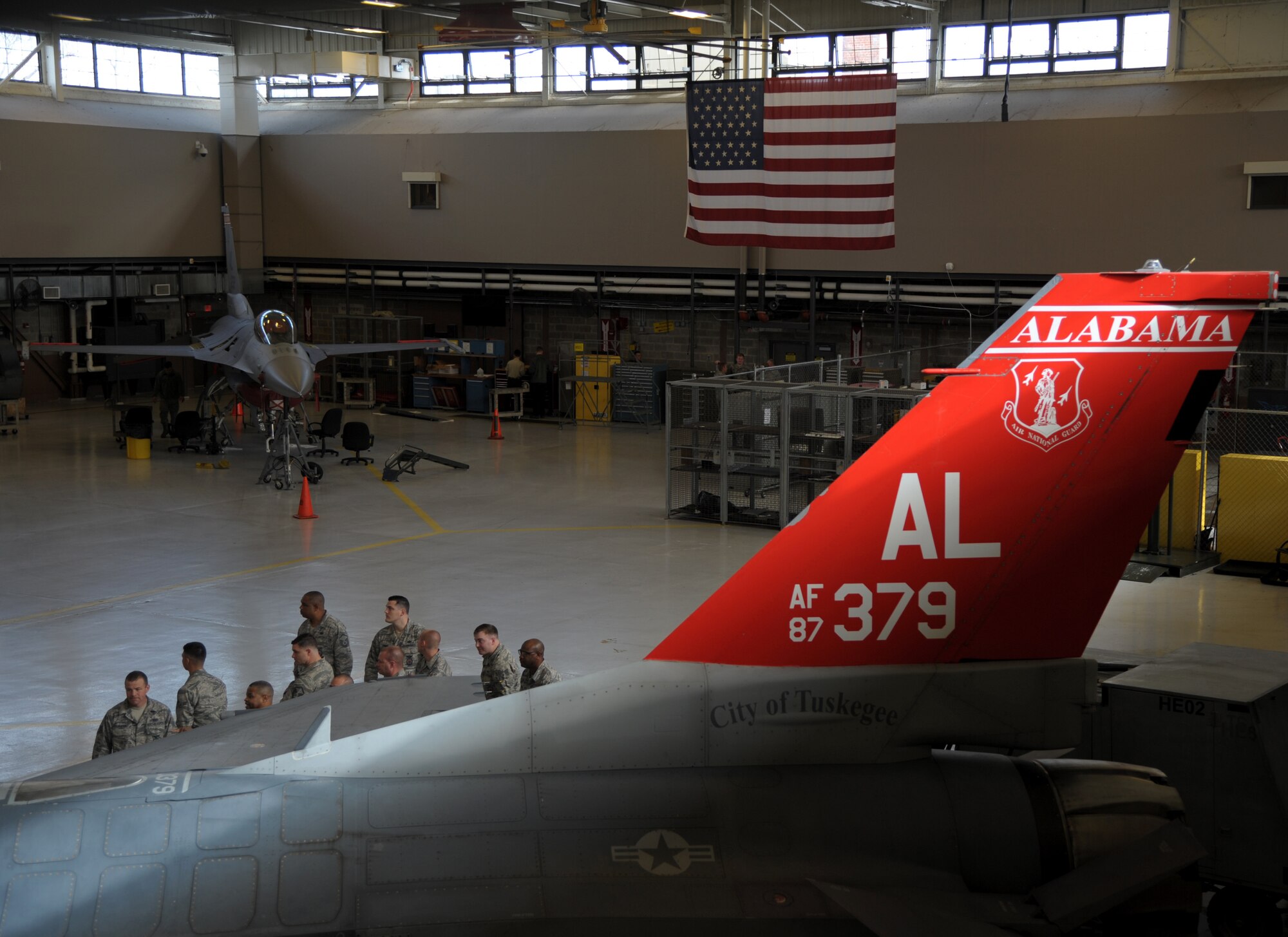 Airmen inside F-16 hangar.