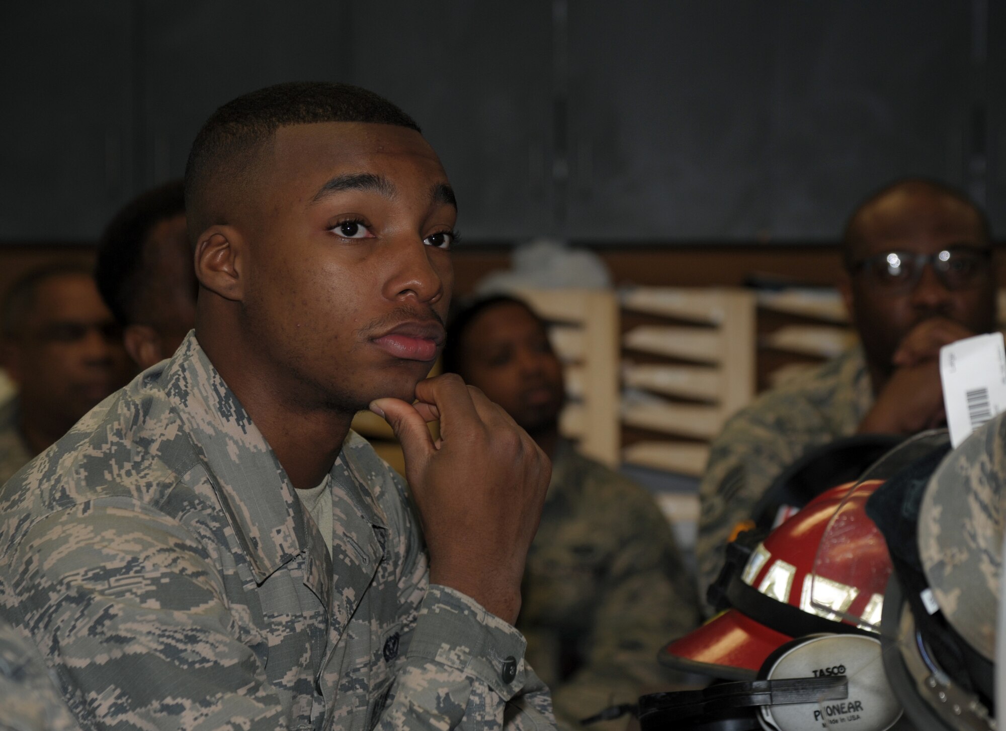 Airmen look and listen to instructor during firefighter safety briefing