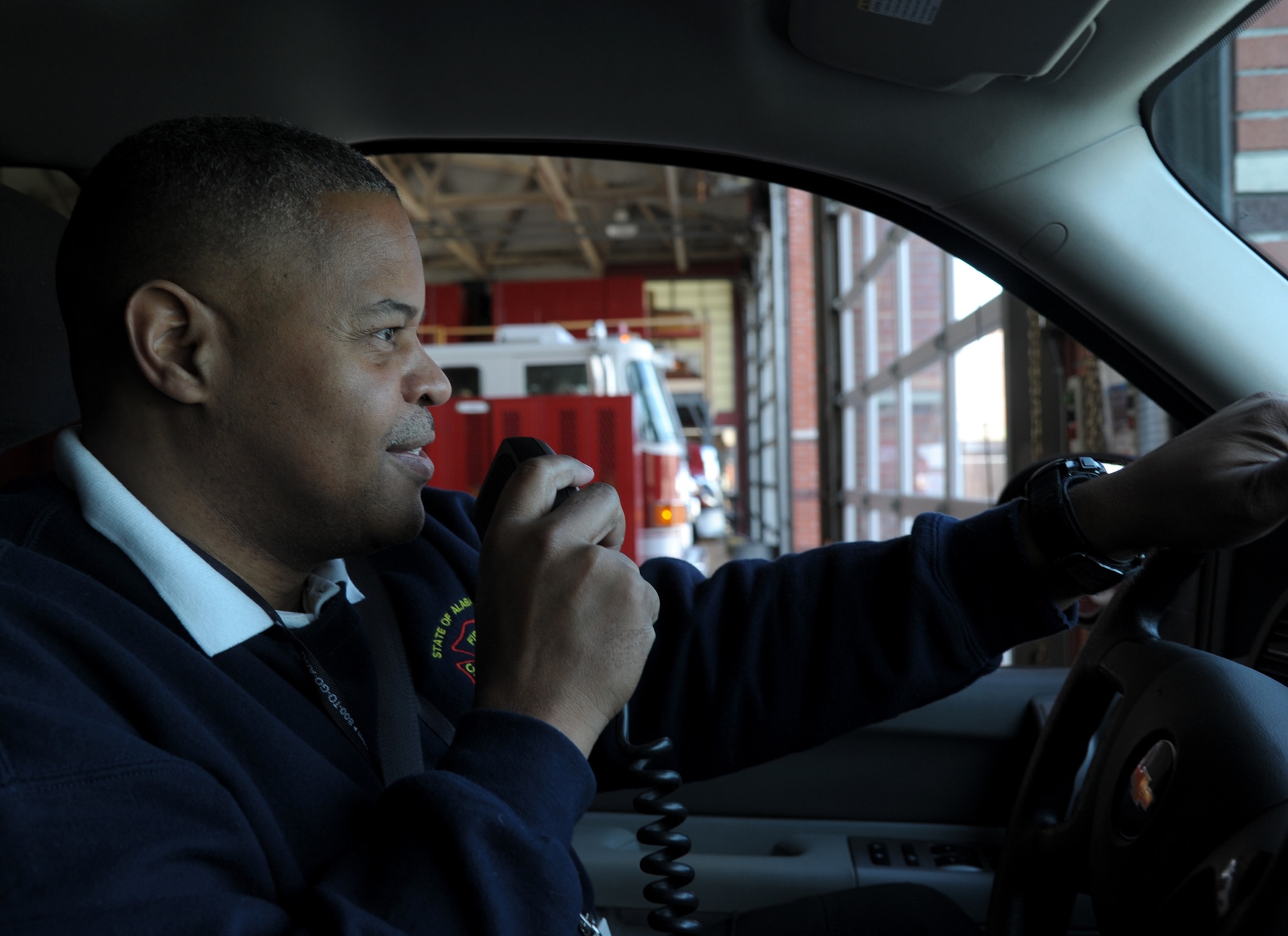 Firefighter chief uses radio inside fire truck.