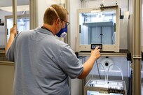 Code 930 Nuclear Continuous Training and Development (CTD) Coordinator Kyle Cooper sets up one of six printers in his department to 3-D print a prototype.