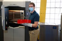 Norfolk Naval Shipyard Technology and Innovation (T&I) Lab Team Member James Klein displays 3-D printed headband from the T&I Lab's 3-D printer.