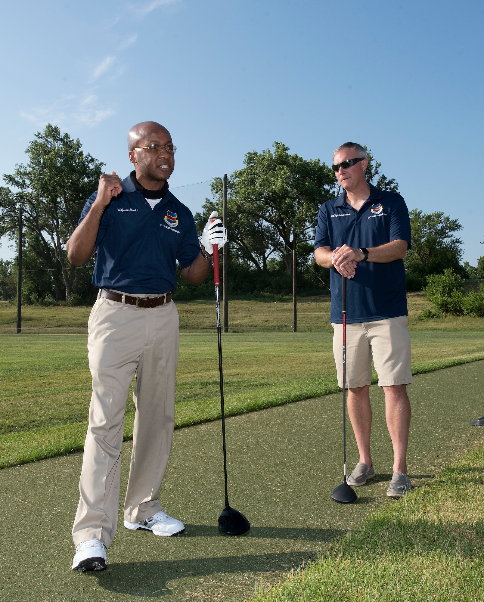 Men standing on golf course.