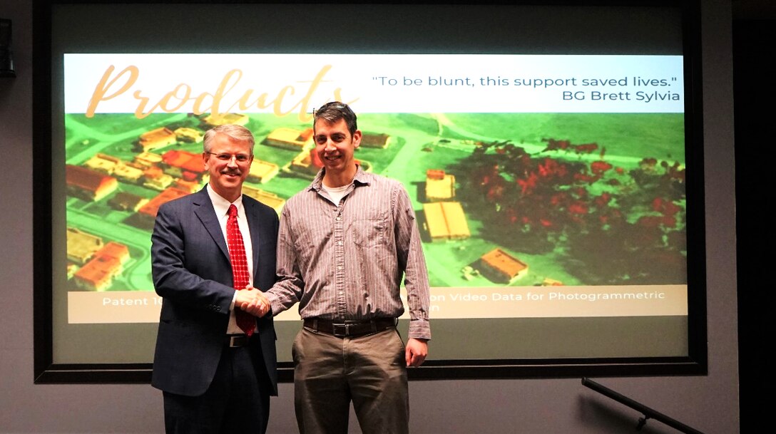 U.S. Army Engineer Research and Development Center Director Dr. David Pittman, left, congratulates Dr. Ricky Massaro of the Geospatial Research Laboratory in Alexandria, Va., on his U.S. Patent received in February 2020 for his “Method of Processing Full Motion Video Data for Photogrammetric Reconstruction."