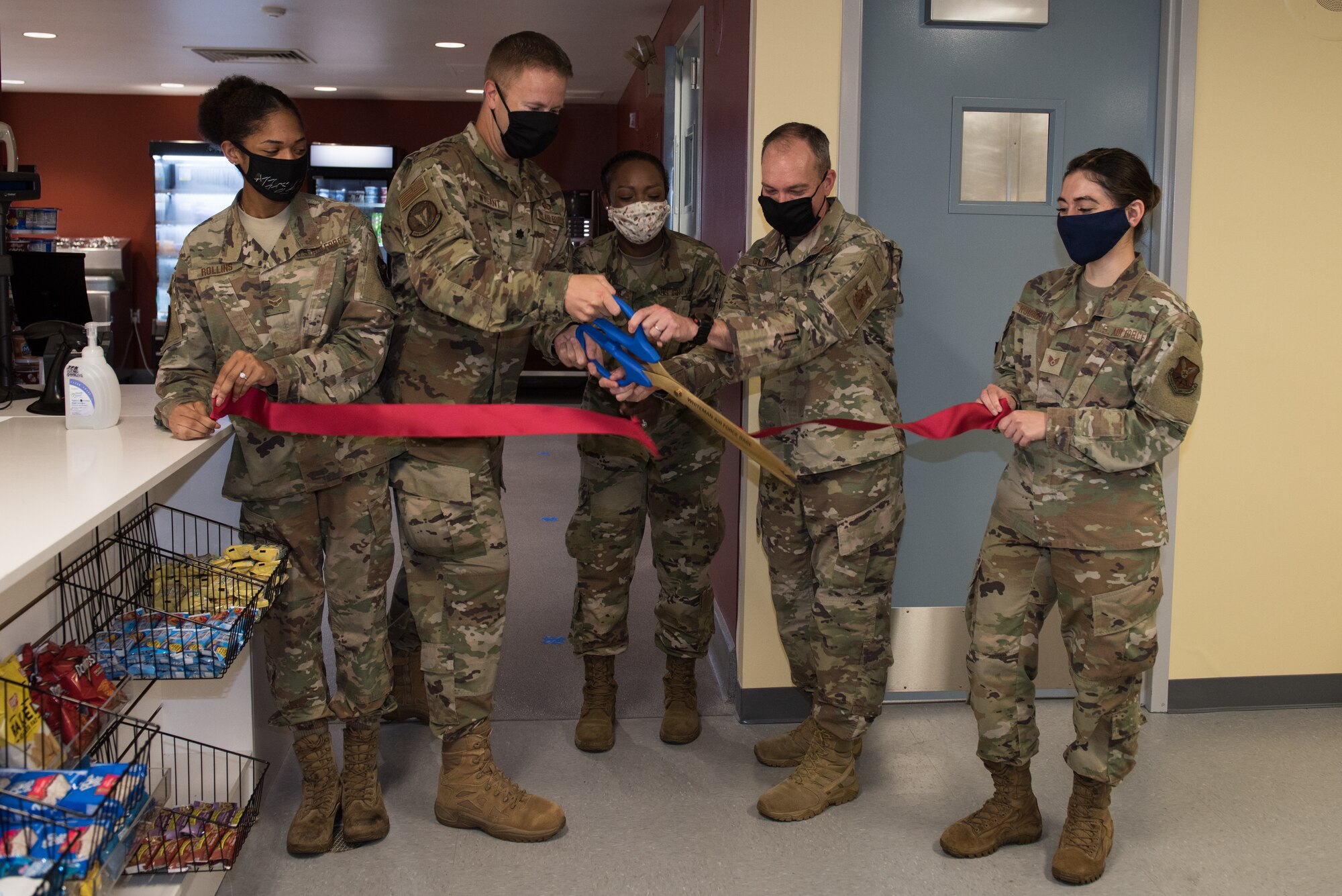 U.S. Air Force Lt. Col. Jacob Wygant, 509th Force Support Squadron commander, opens the Touch & Go In-Flight Kitchen during a ribbon cutting ceremony on Whiteman Air Force Base, Missouri, June 29, 2020. The IFK offers a grab and go meal option and a dine-in hot meal option for members with flight line access. (U.S. Air Force photo by Airman 1st Class Christina Carter)