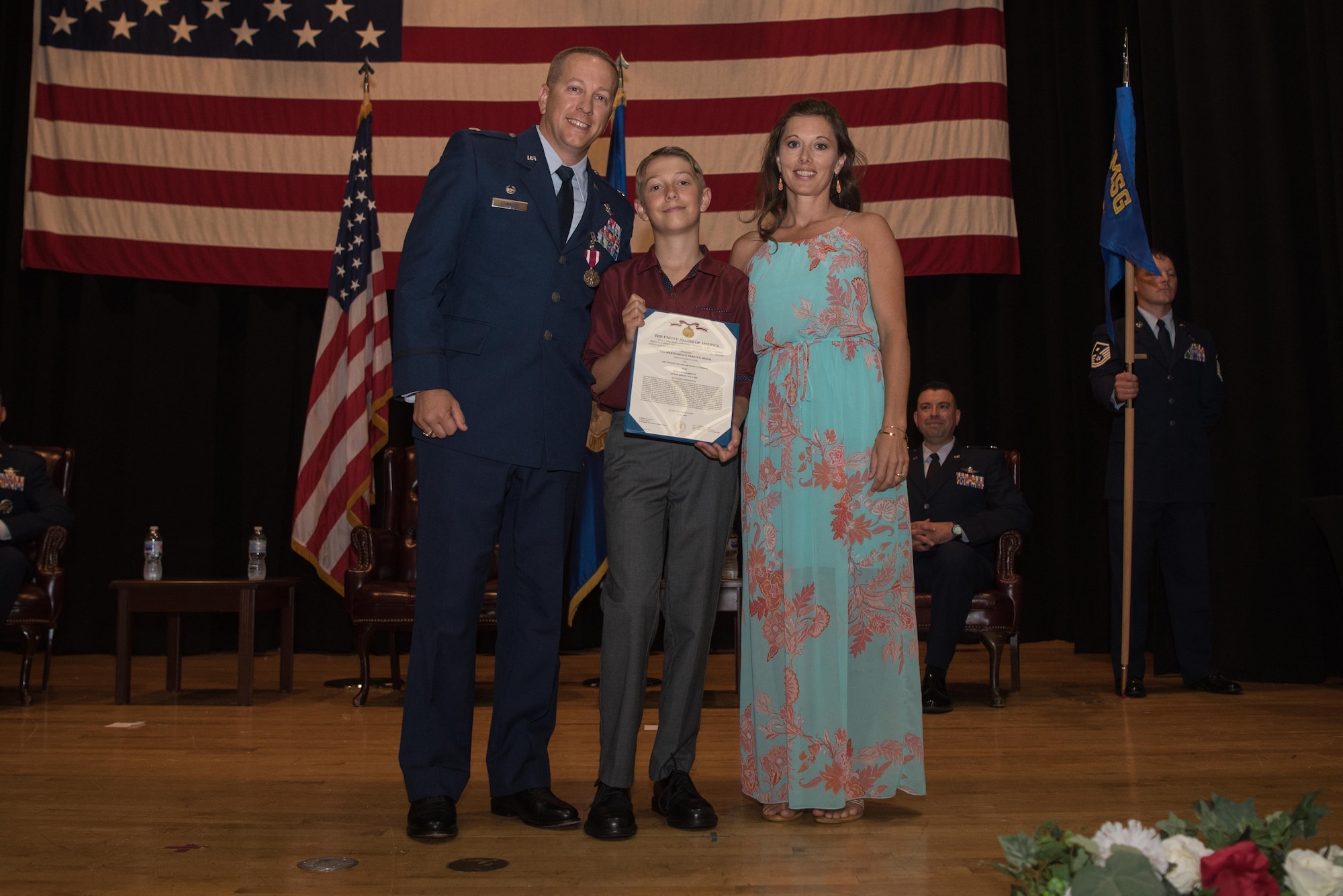 Lt. Col. Shannon Cummins, 22nd Communications Squadron outgoing commander, is presented the Meritorious Service Medal by his wife Sarah and son Gavin, July 8, 2020, at McConnell Air Force Base, Kansas. The Meritorious Service Medal is awarded to members of the U.S. Armed Forced who distinguished themselves by outstanding noncombat meritorious achievement or service. (U.S. Air Force photo by Senior Airman Alexi Bosarge)