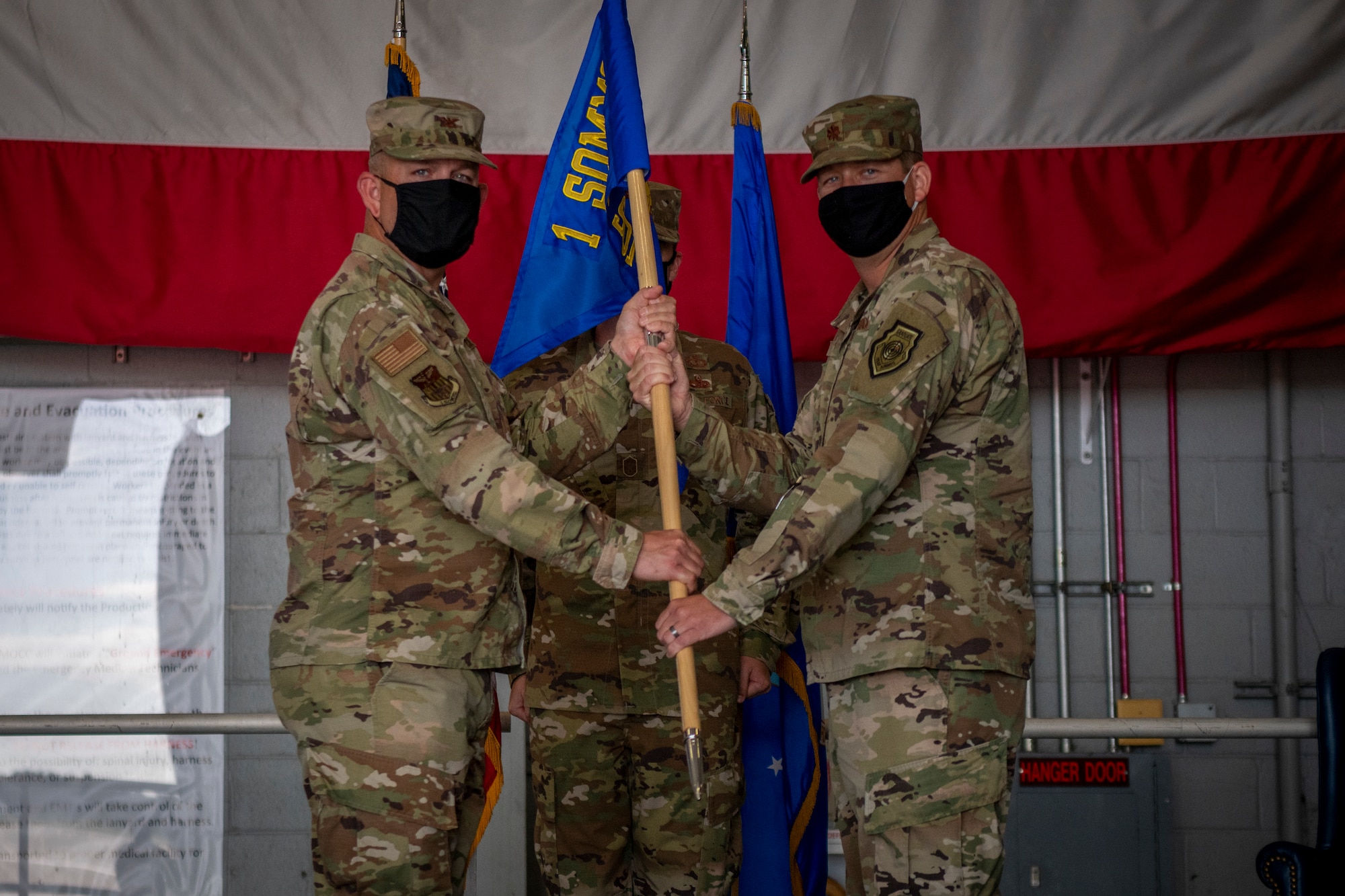 U.S. Air Force Col. Anthony Babcock, commander of the 1st Special Operations Maintenance Group, (left) hands a guidon to U.S. Air Force Maj. Clayton Seiler, incoming commander of the 1st Special Operations Munitions Squadron, during the 1st SOMUNS activation ceremony at Hurlburt Field, Florida, July 8, 2020.