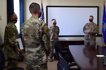 Civil Engineering Airmen brief 99th Air Base Wing Leadership in a conference room.