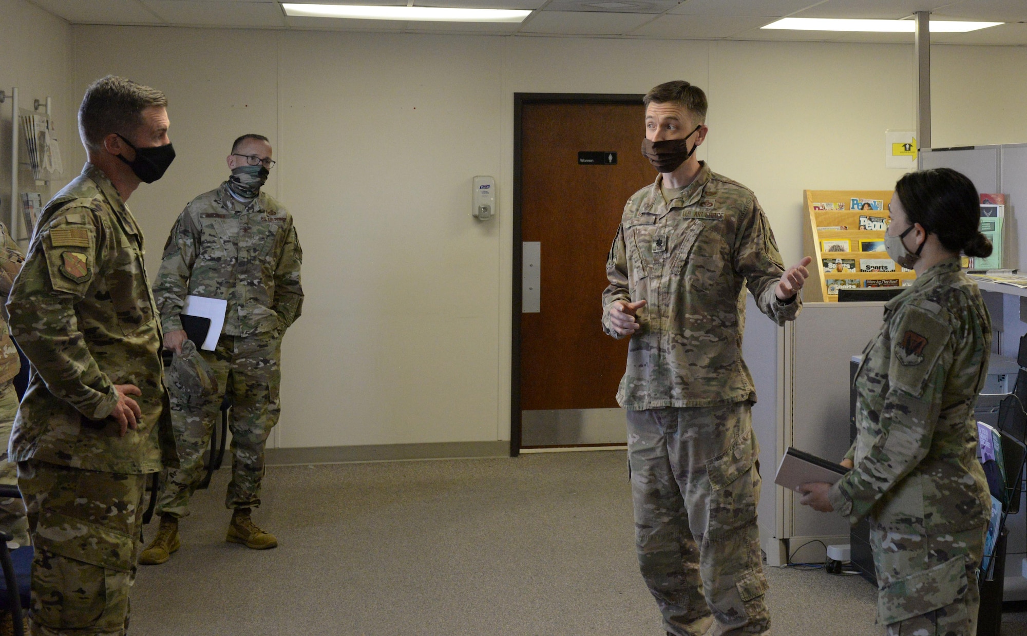 Airmen brief 99th Air Base Wing leadership in the personnel flight trailer's front room.