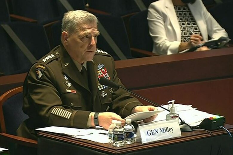 A man sits speaks into a microphone.