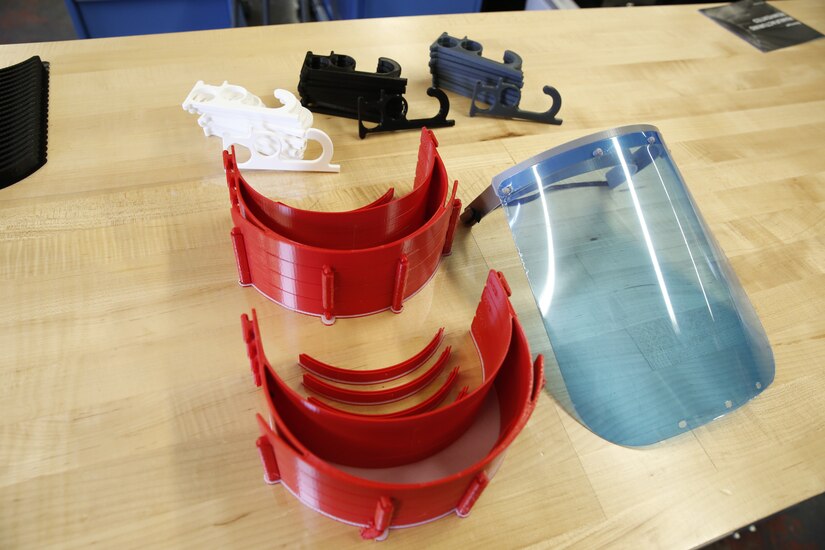 3-D printed personal protective equipment components are displayed on a table.