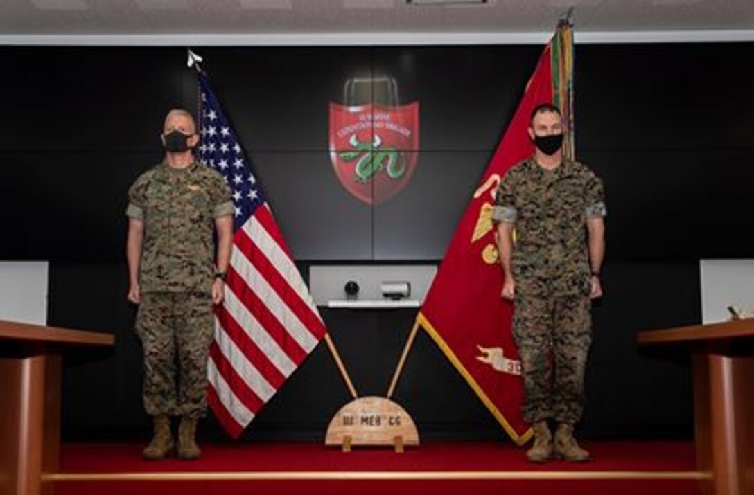 Maj. Gen. Paul J. Rock, left, outgoing commanding general of 3D Marine Expeditionary Brigade, and Brig. Gen. Kyle B. Ellison, right, incoming commanding general of 3D Marine Expeditionary Brigade, participate in a change of command ceremony at Camp Courtney, July 10, 2020. The ceremony represents the transfer of authority, responsibility, and accountability from the out-going commanding general to the incoming commanding general.
