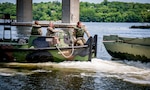 Soldiers assigned to the Connecticut National Guard's 250th Multi-Role Bridge Company drive a bridge erection boat into position to grab a section of an improved ribbon bridge during training on the Thames River in New London, Connecticut, June 10, 2020. The IRB team practiced creating a five-float raft, which is designed to transport troops, equipment, and vehicles across a river.