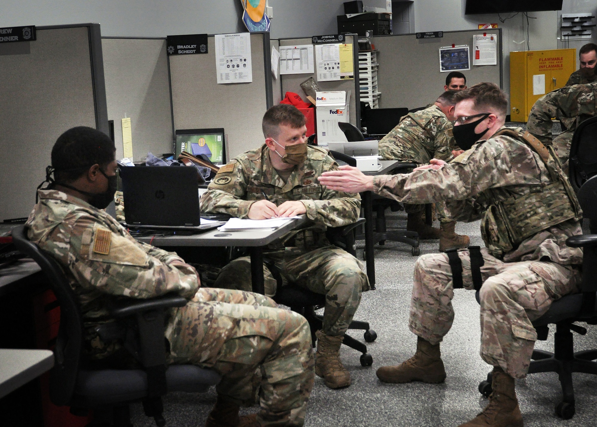 (left to right) Members of the 445th Security Forces Squadron, Staff Sgt. Daryn Weatherspoon, unit training instructor; Tech. Sgt. Jacob McCorkle, lead unit trainer; and Staff Sgt. Mitchiner Underhill, fire team member, perform a tabletop evaluation to test Airman’s knowledge of cover and concealment, flanking procedures and moving as a firing team, June 6, 2020.  Discussions like these are now completed in small groups to comply with social distancing guidelines.