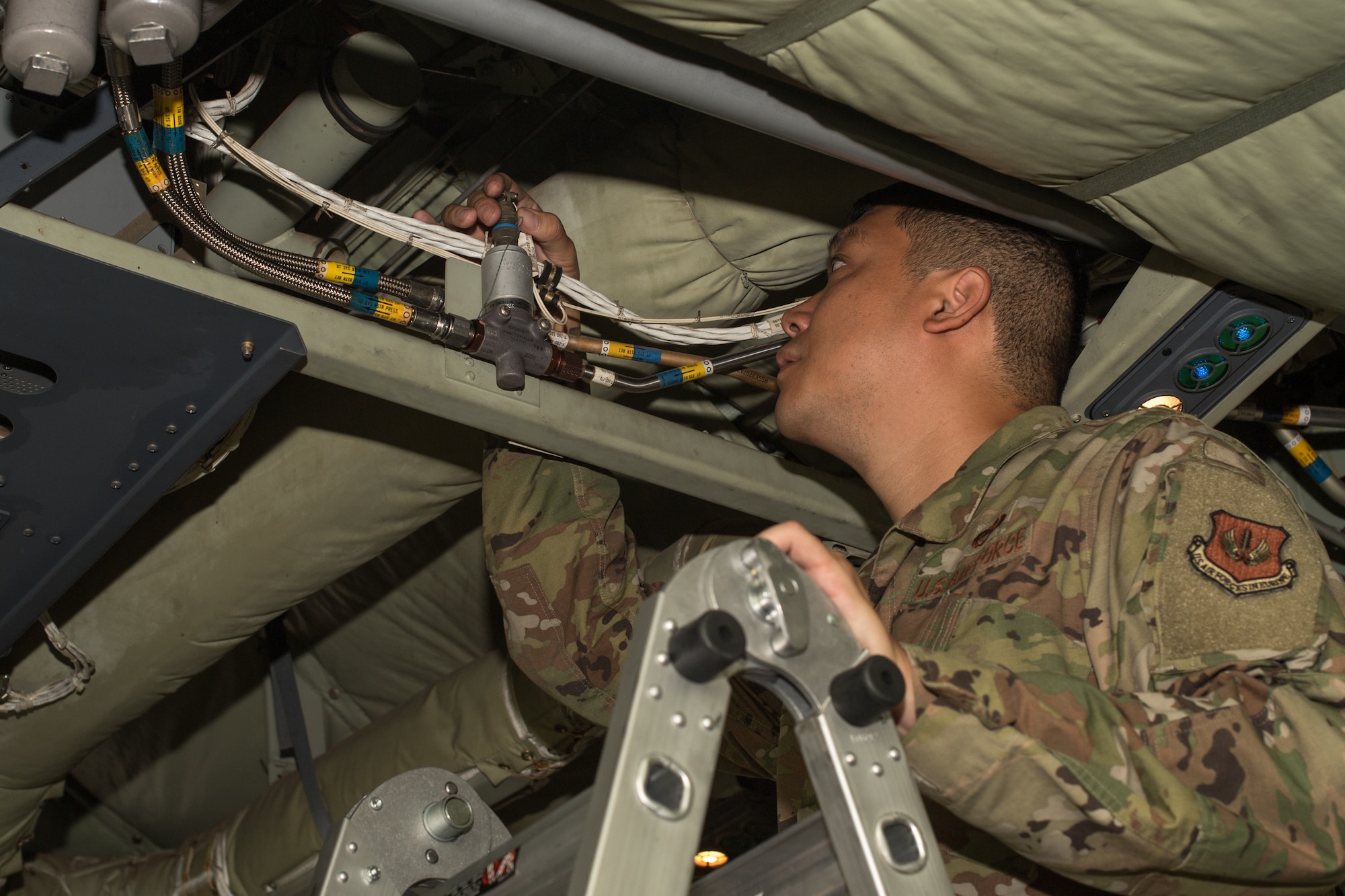 An Airman inspecting wires.