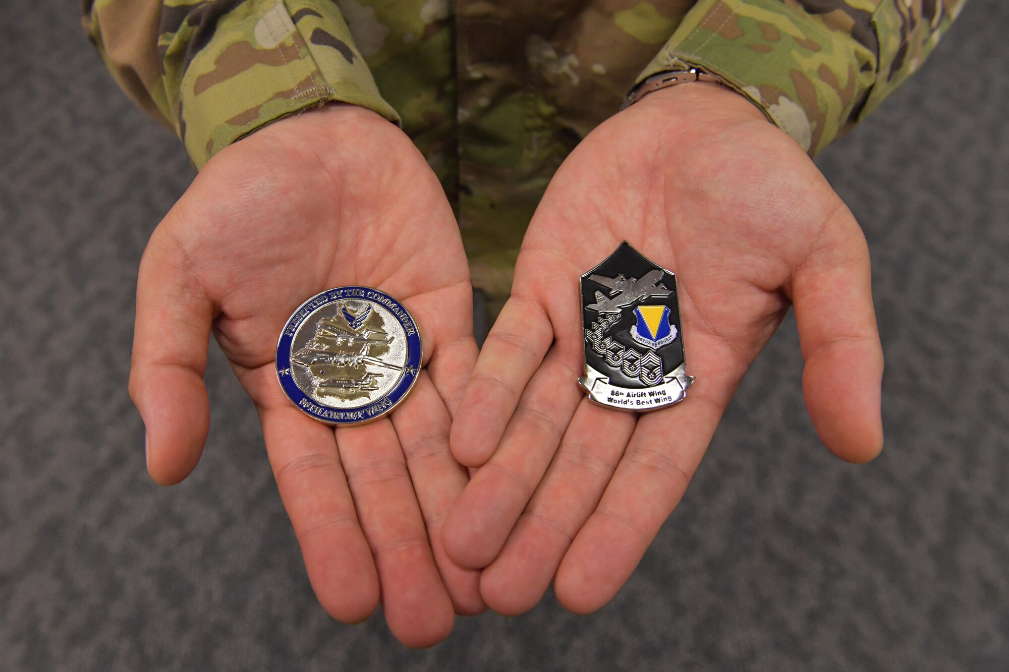 A close-up of hands holding two coins.