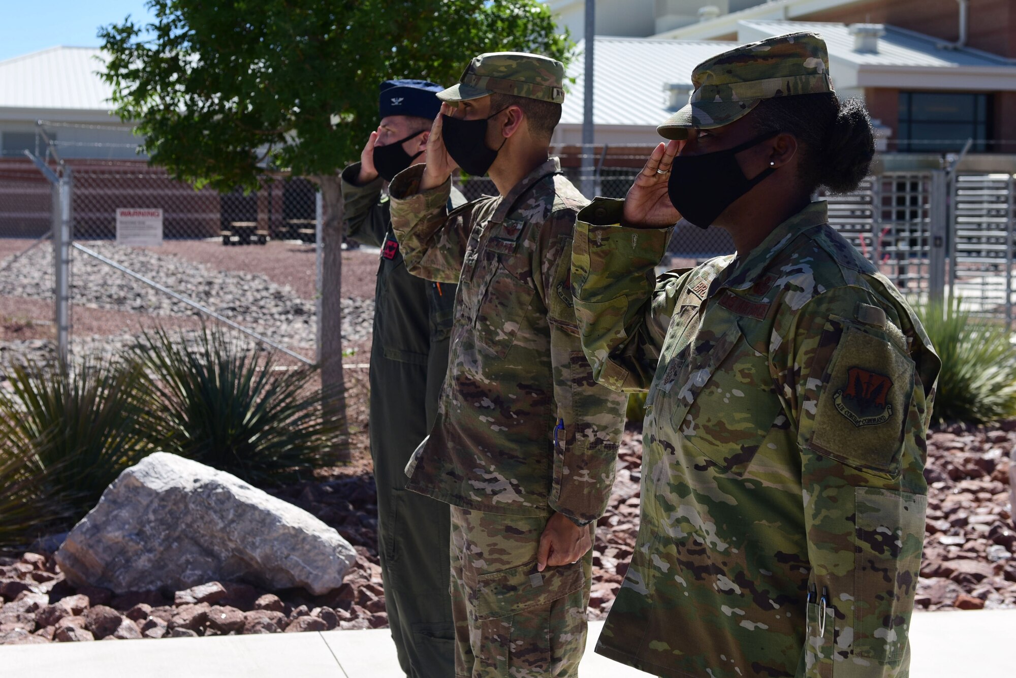 Col. Stephen R. Jones, 432nd Wing/432nd Air Expeditionary Wing commander, Col. Jason B. Bell, 432nd WG/432nd AEW vice commander, and Chief Master Sgt. Michelle T. Browning, 432nd WG/432nd AEW command chief, salute the staff vehicle carrying U.S. Deputy Secretary of Defense David L. Norquist during a visit at Creech Air Force Base.