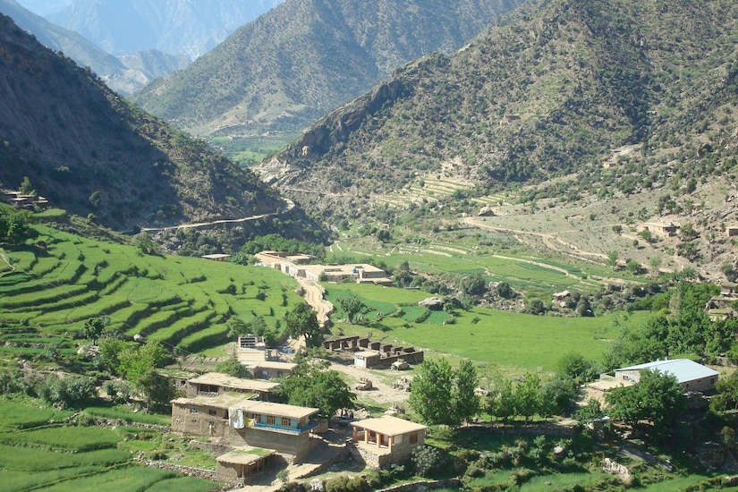 A small town sits in a valley between mountains.