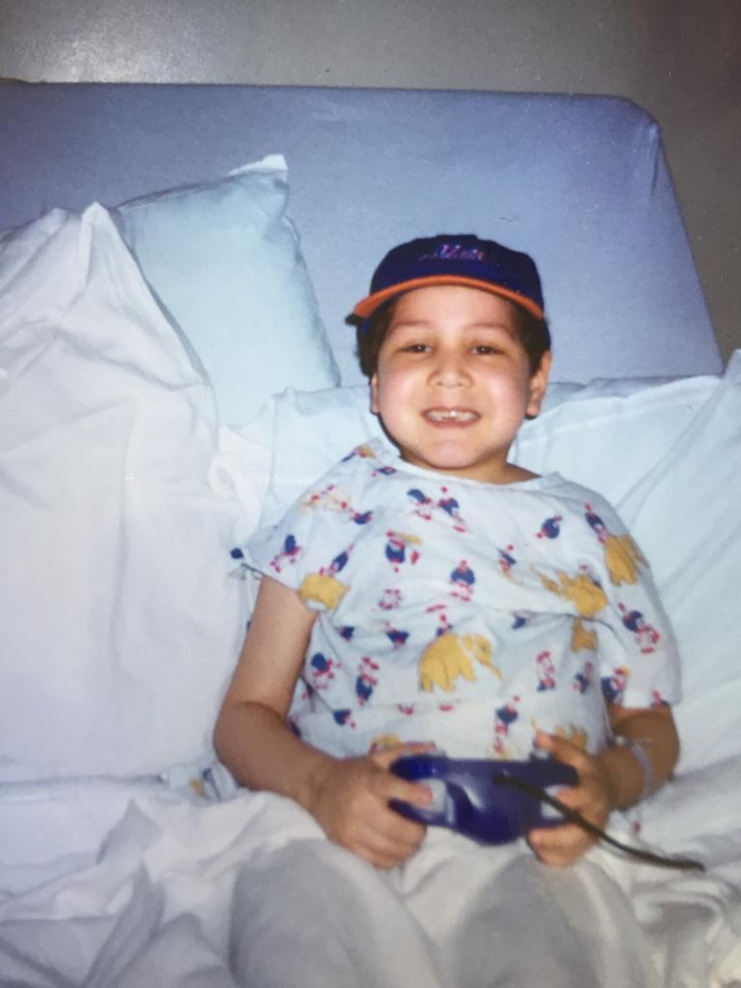 Airman 1st Class Isaiah A. Nieves, 2nd Maintenance Squadron aerospace ground equipment journeyman, plays video games in a hospital bed as a child. Nieves was diagnosed with Acute Lymphoblastic Leukemia at the age of four. (Courtesy photo)