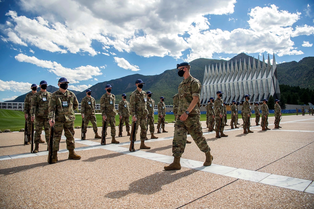 Basic cadets in protective gear stand in formation.