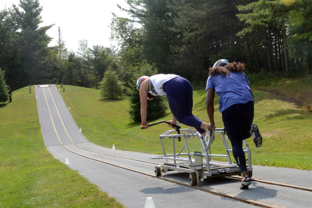 Bobsledders barrel down a railway track.