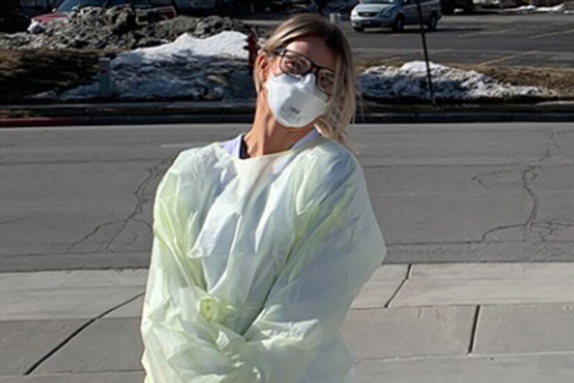 Woman in personal protective equipment poses for photo.