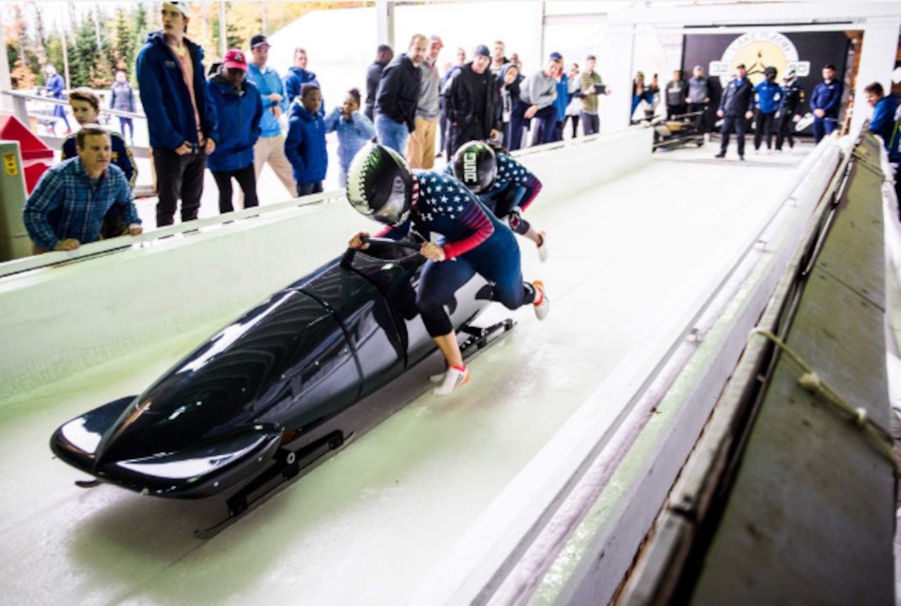 Bobsledders barrel down a railway track.