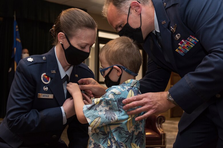 Lt. Col. Emily Arthur, prior 47th Contracting Flight commander, receives the Meritorious Service Medal at Laughlin Air Force Base, Texas, July 10, 2020. Her son, Ryker, and husband, Lt. Col. Todd Arthur pin the medal for her as they all wear masks to prevent the spread of COVID-19. (U.S. Air Force photo by Senior Airman Anne McCready)