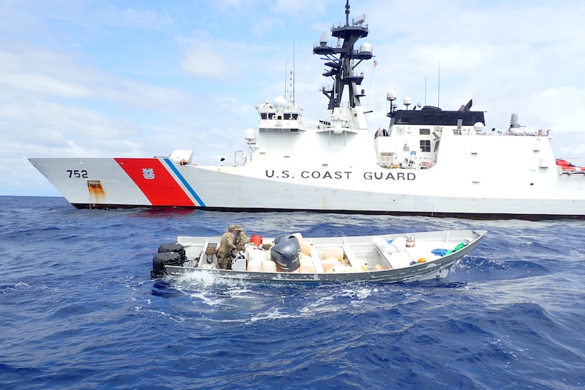 Service members search a small boat.