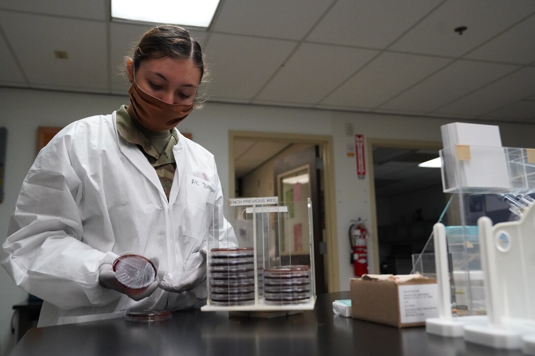 U.S. Air Force Airman 1st Class Alexandria Johnson, 81st Diagnostic and Therapeutics Squadron lab technician, reviews  a bacteria sample inside the Keesler Medical Center at Keesler Air Force Base, Mississippi, July 2, 2020. The Microbiology Department has been working to get fast, efficient, and accurate COVID test results to their patients. (U.S. Air Force photo by Airman 1st Class Spencer Tobler)