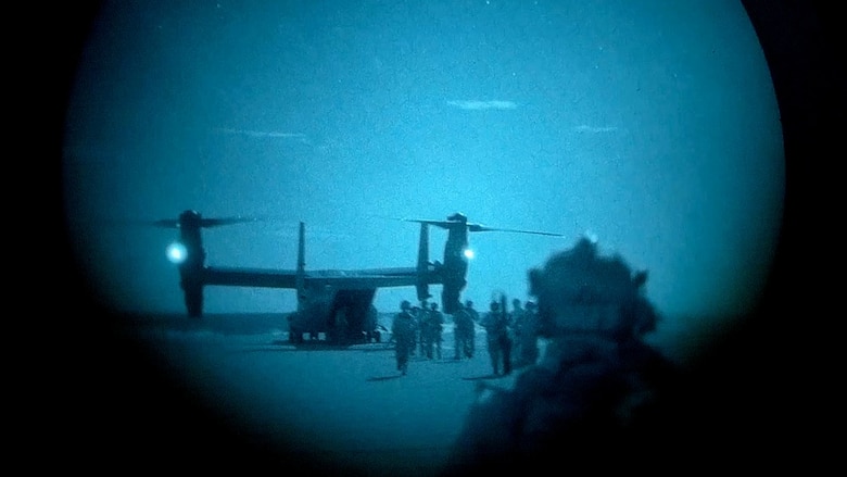 Air Force Special Tactics operators and simulated partner forces load a CV-22 Osprey,