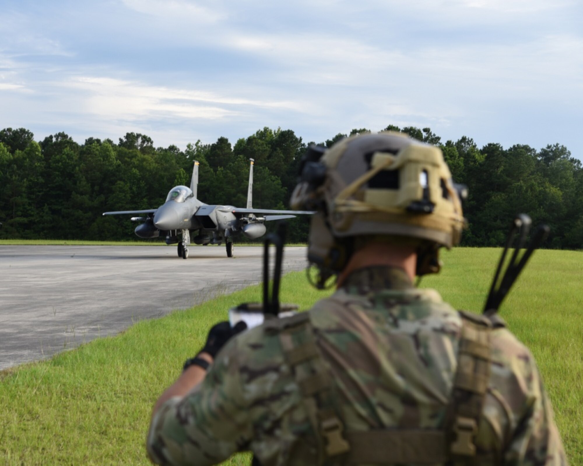 An Air Force Special Tactics operator helps secure an airfield for an F-15 fighter aircraft during a Forward Air Refueling Point training mission