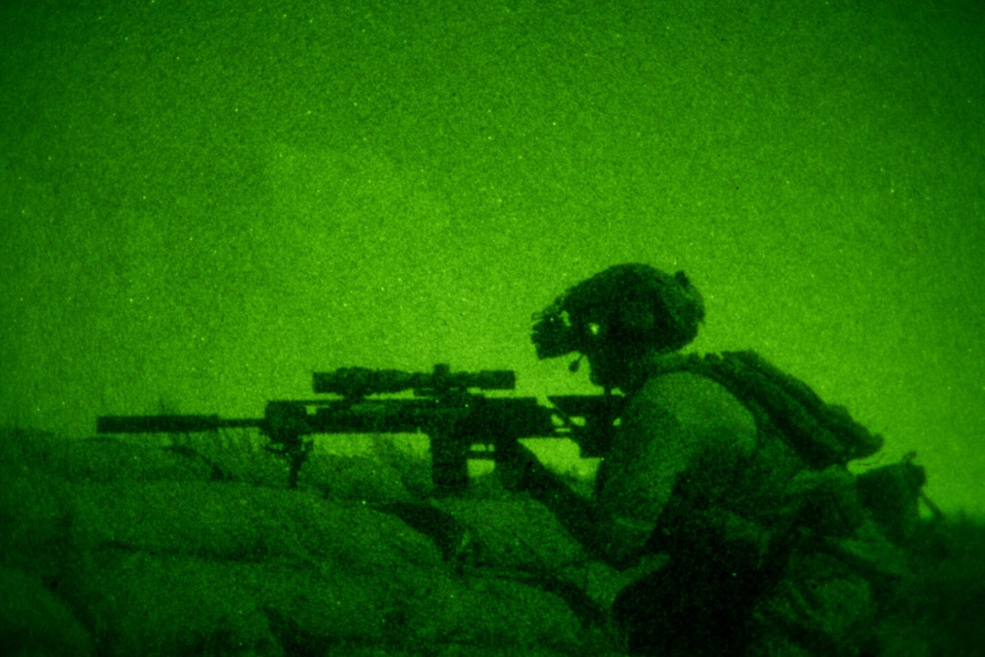 An Air Force Special Tactics operator positions his MK20 rifle on top of a berm to pull security for the command and control element during a full mission profile