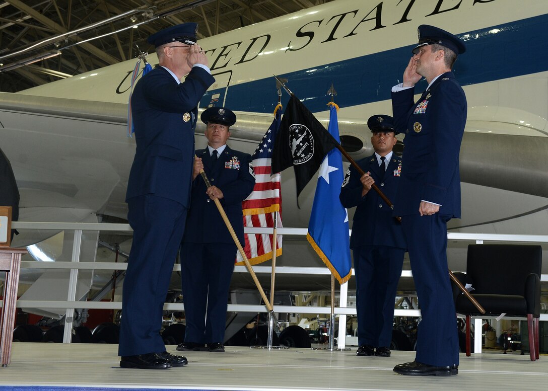 Airmen salute one another in front of E-4B aircraft