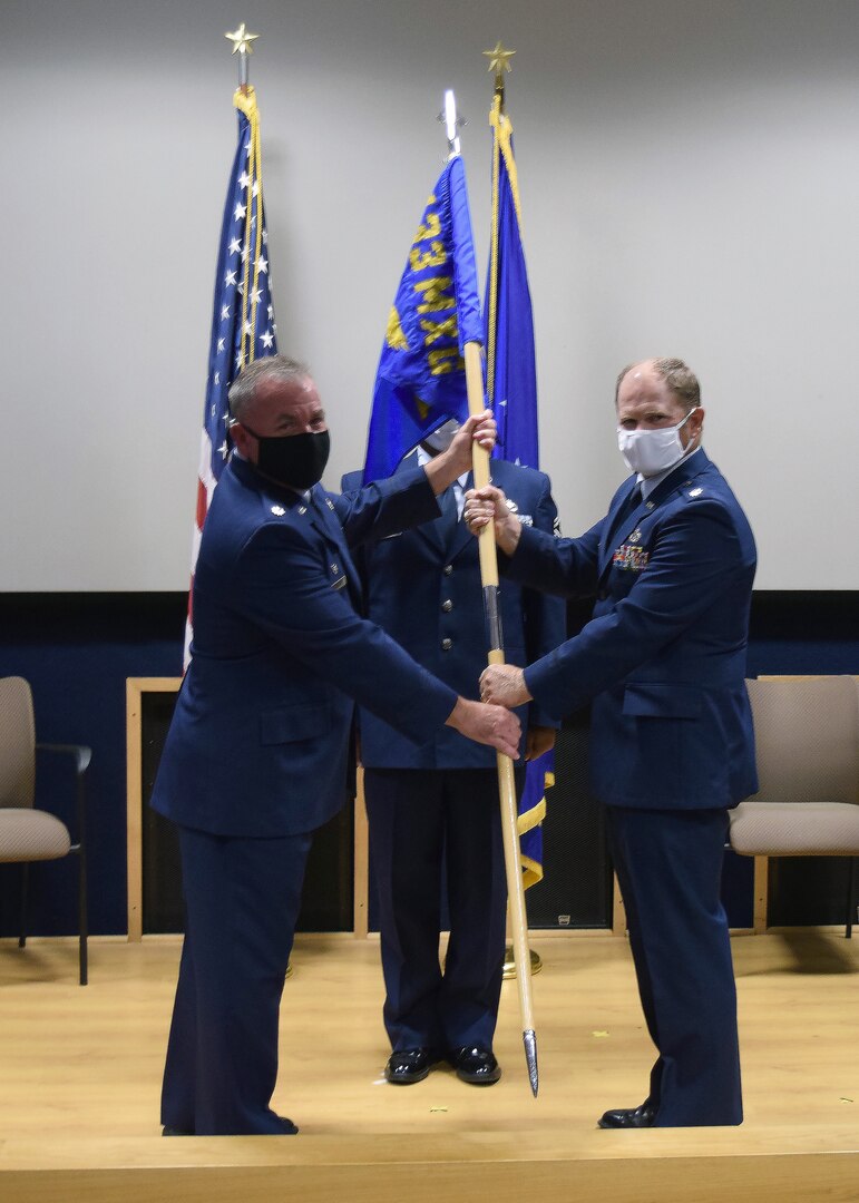 Lt. Col. Stuart Martin, 433rd Maintenance Group commander, presents the guidon to Lt. Col. A. Spence Pennington, 433rd Aircraft Maintenance Squadron commander, at a change of command ceremony for the 433rd AMXS July 11, 2020 at Joint Base San Antonio-Lackland, Texas.