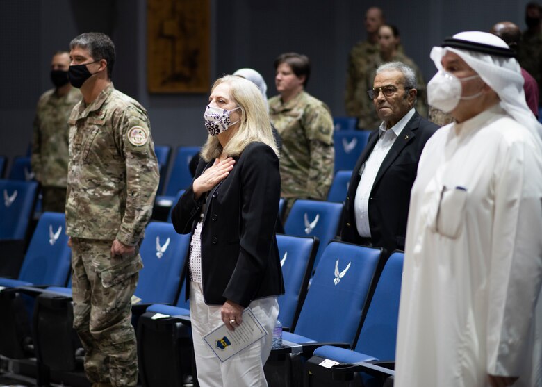 Ambassador holds hand over heart during U.S. National Anthem.