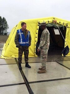 U.S Army Reserve Maj. Ralph Scott, commander of the 773rd Civil Support Team, 7th Mission Support Command, right, shares tactics, techniques and procedures with Netherlands Maj. Rens, commander of the CBRN Response Unit, during a training exercise in Gravendeel, Netherlands, July 8. The one-day CBRN situational training exercise focused on a CBRN incident on a maritime vessel at the Dutch Harbor in Gravendeel, Netherlands.  (U.S Army Reserve Photo by 1st Sgt. Domenic Barbeiro).