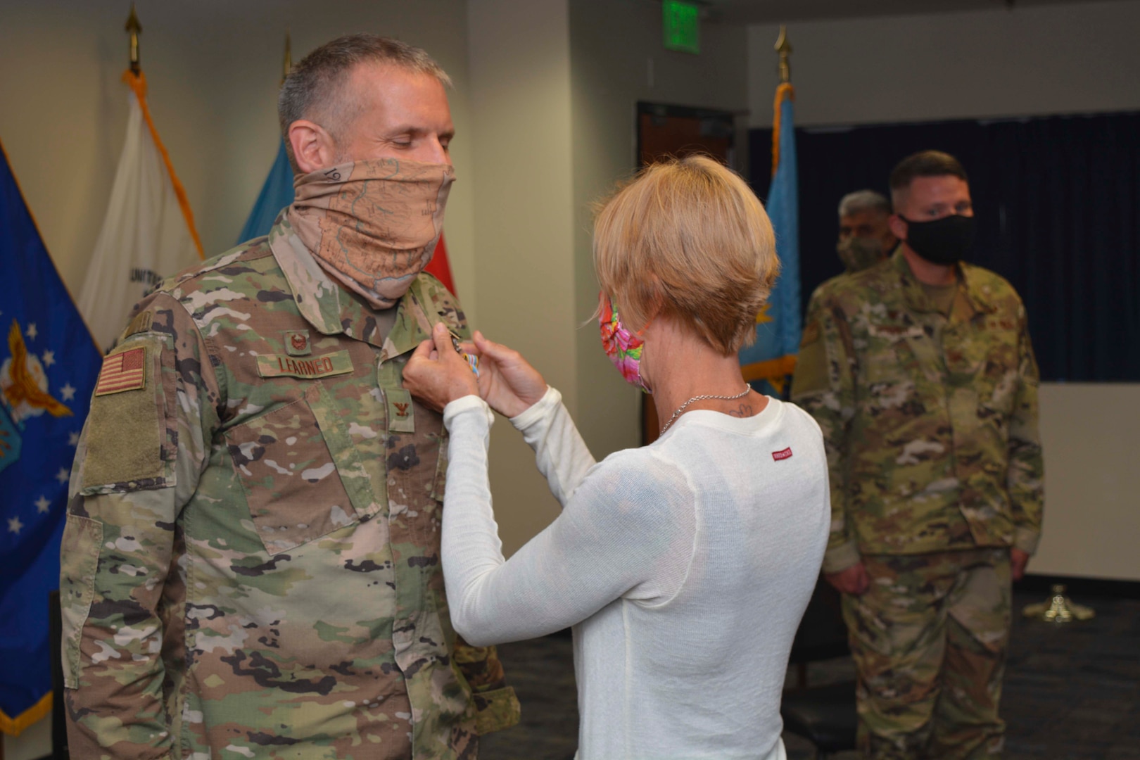 A woman pins an award on a man's chest