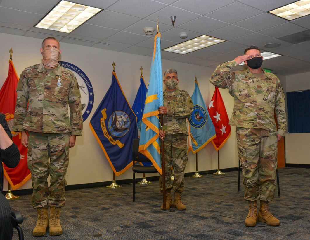 Three men stand during a ceremony