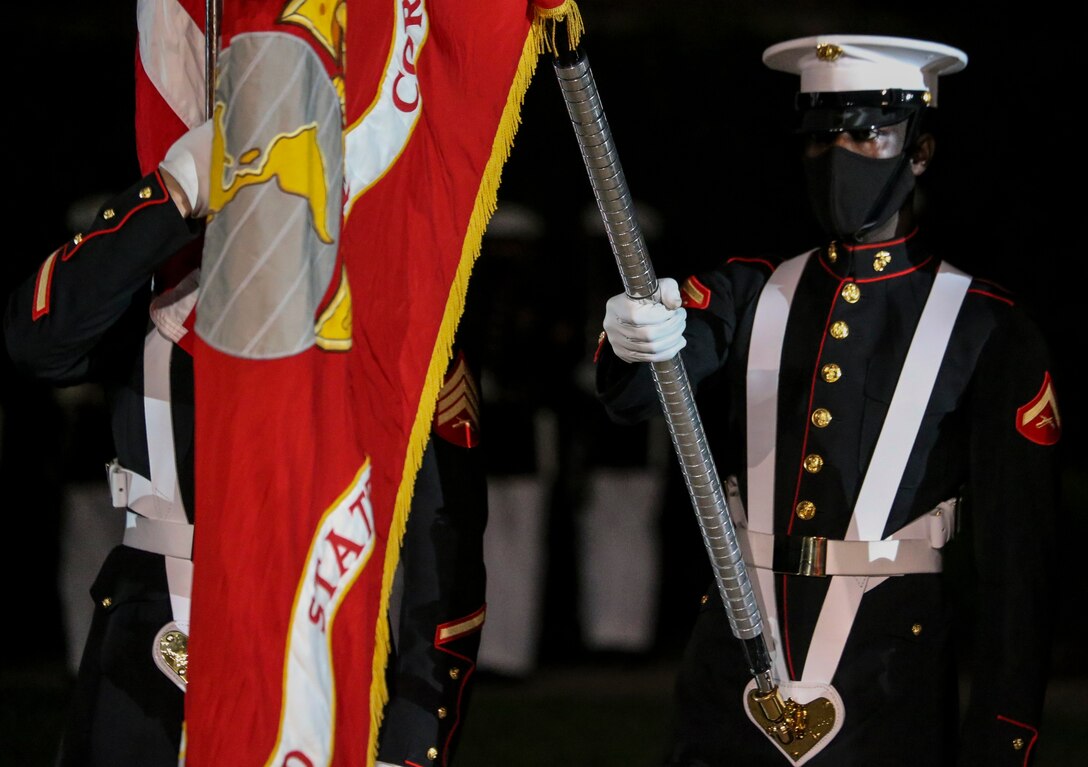 Sergeant Franklin D. Taft, 39th color sergeant of the Marine Corps, and Lance Cpl. Alioune Fode, organizational flag bearer, present the National Ensign during a Friday Evening Parade at Marine Barracks Washington, D.C., July 7, 2020. Admiral Michael M. Gilday, chief of naval operations, was the guest of honor, and the hosting official was the 38th Commandant of the Marine Corps, Gen. David H. Berger. (U.S. Marine Corps photo by Cpl. James Bourgeois)