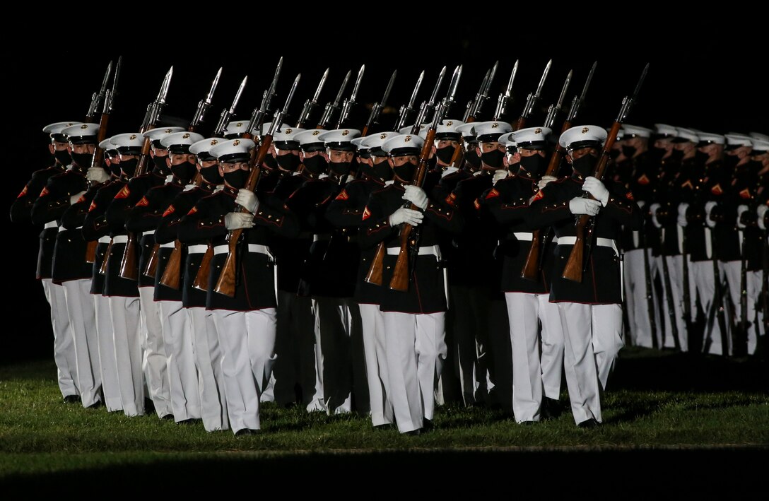 Marines with the Silent Drill Platoon perform during a Friday Evening Parade at Marine Barracks Washington, D.C., July 7, 2020. Admiral Michael M. Gilday, chief of naval operations, was the guest of honor, and the hosting official was the 38th Commandant of the Marine Corps, Gen. David H. Berger. (U.S. Marine Corps photo by Sgt. Robert Knapp)