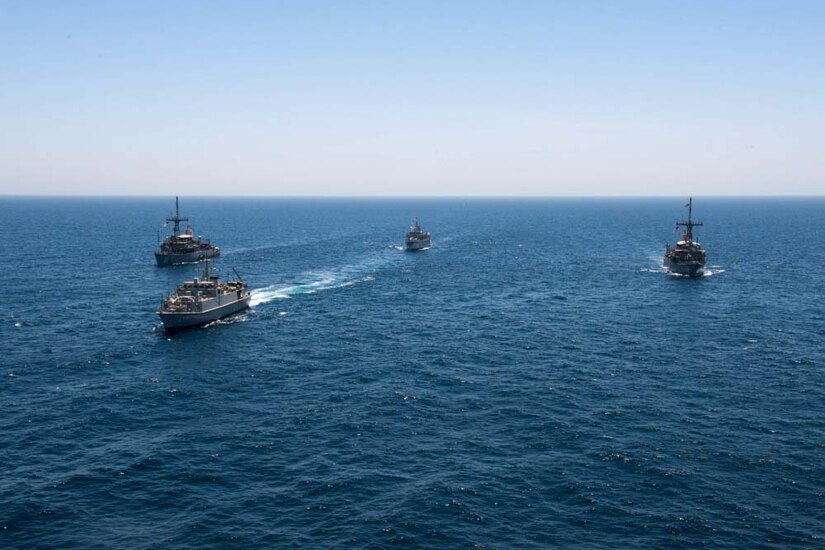 Four ships moves across the ocean.