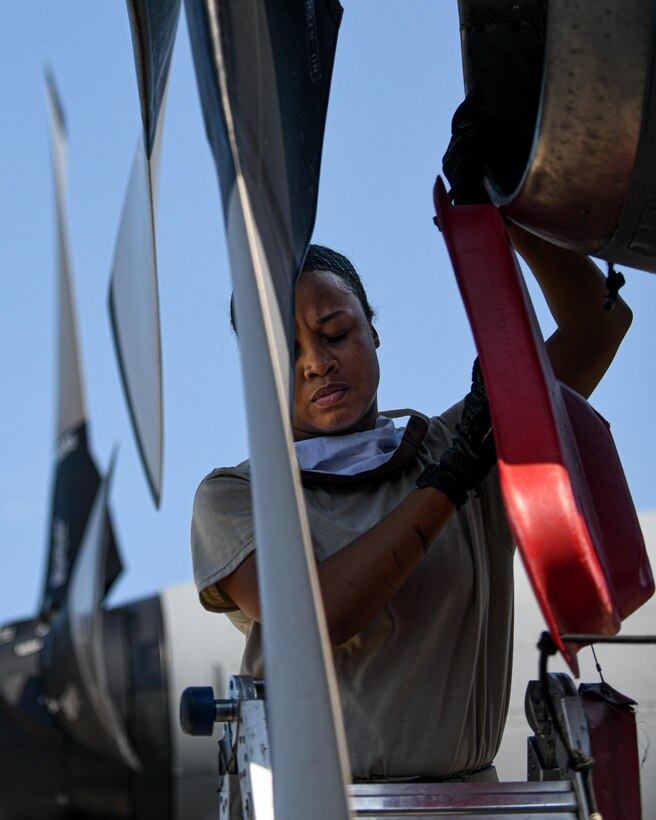 Senior Airman Dayna Jones, a crew chief with the 910th Maintenance Squadron, removes a protective shield to perform a thru-flight inspection on a C-130H Hercules on Youngstown Air Reserve Station’s flightline, July 7, 2020. Crew chiefs use thru-flight inspections to search for any loose, broken or corroded parts and foreign material prior to takeoff.