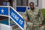 Intelligence Specialist 2nd Class Joshua James, from Savannah, Ga., stands in front of the entrance of Commander, Carrier Strike Group (CCSG) 15. CCSG-15 conducts integrated training to provide Fleet Commanders with deployable combat ready maritime forces in support of global operations. (U.S. Navy photo by Mass Communication Specialist 1st Class Christopher Cavagnaro/Released)